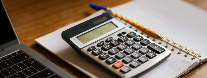 Calculator and financial documents illustrating the cost of extended customer payment terms