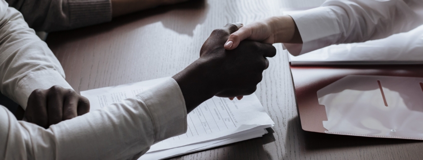 Business partners shaking hands over contract documents, illustrating customer relationship concentration risk