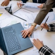 Business team reviewing financial charts and laptop data together during a management meeting