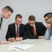 Executive team reviewing acquisition integration documents — Sebastian Herrmann / Unsplash Business executives reviewing documents together at a conference table during an acquisition integration meeting