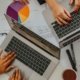 Overhead view of finance professionals reviewing charts and laptops during a strategic forecast meeting