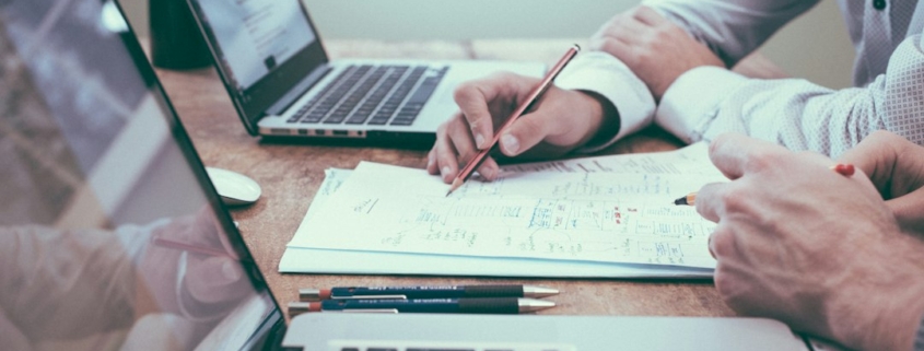 Finance professionals reviewing financial charts and documents during a forecasting meeting
