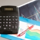 Calculator and pen beside financial charts illustrating price volume mix revenue analysis