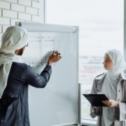Business professionals planning and updating a forecast on a whiteboard