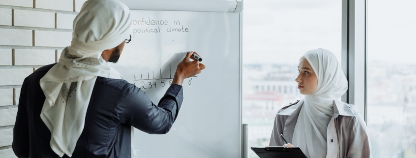 Business professionals planning and updating a forecast on a whiteboard