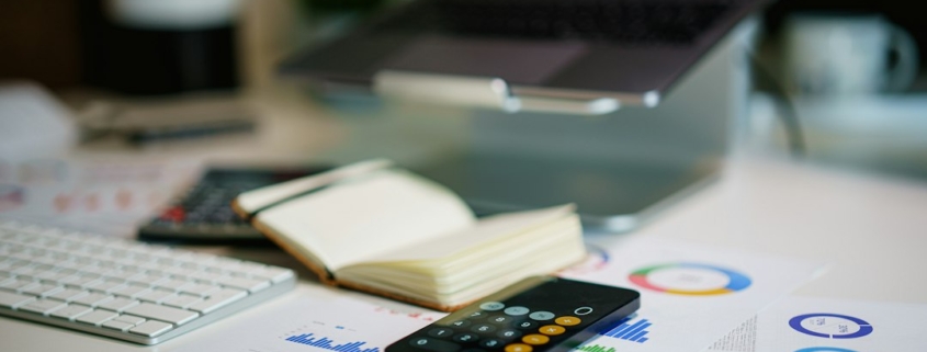 Financial reports and calculations on a desk illustrating accounts receivable collections forecasting