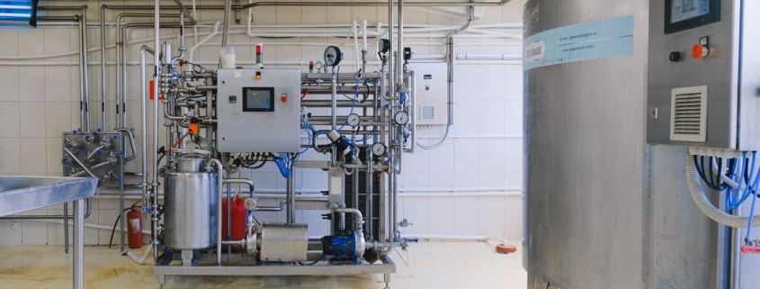 Industrial manufacturing equipment inside a modern factory, illustrating a lease versus buy equipment decision