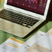 Laptop and financial documents used to analyze supplier bulk discounts and inventory purchasing costs