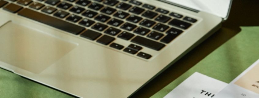 Laptop and financial documents used to analyze supplier bulk discounts and inventory purchasing costs