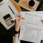 When Should I Hire a Controller? Person reviewing financial documents with a calculator and laptop