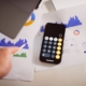 Laptop, calculator and financial reports on a desk for FP&A software implementation planning
